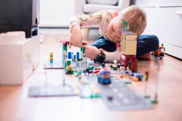 Dreng der leger mens han har Xplora smartwatch rundt om håndleddet