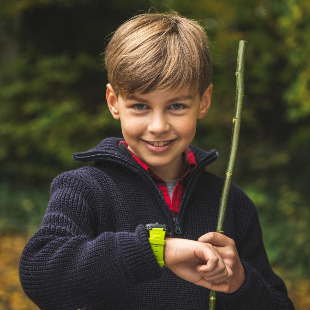 Ung dreng med hans XGO2 børneur i fokus - barnets første mobiltelefon fra Xplora