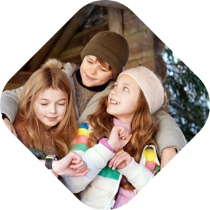 3 børn der sidder med deres Xplora smartwatches til barn som giver tryghed i hele familien